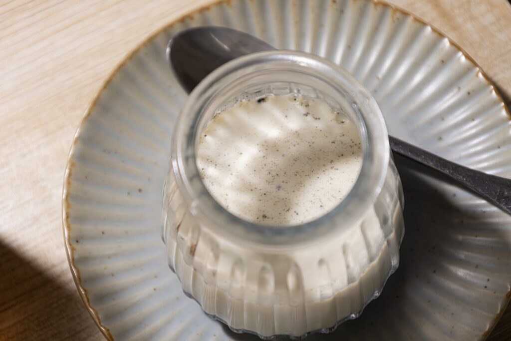 Creamy dessert in a glass jar with spoon